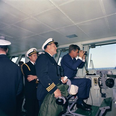 President_Kennedy_aboard_USS_Enterprise_(CVN-65),_watching_maneuvers,_April_1962.jpg